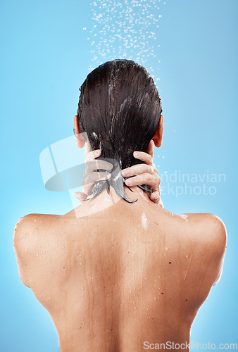 Image of Back, shower and woman hygiene, wellness and body care for health, skincare and against blue studio background. Clean, female and girl wet, natural beauty and water splash to relax and washing.