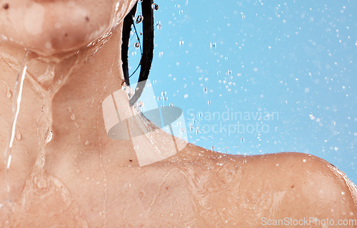 Image of water, shower and woman shoulder closeup for skincare wellness cleaning or healthy morning routine for beauty. Under water, cosmetics treatment and young person washing in blue background studio