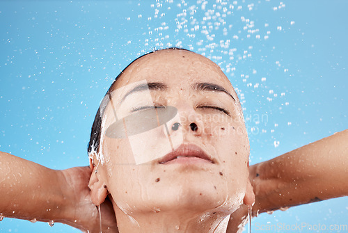 Image of Woman, shower and skincare hydration for beauty, hygiene or cleanse against a blue studio background. Female relaxing for calm cleansing in hygienic wellness, satisfaction or body care treatment