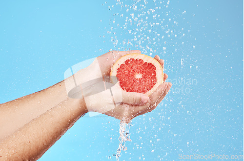 Image of Grapefruit in hands, water splash and studio background for healthy, vegan and wellness food on advertising, marketing or promotion mockup. Detox, vitamin c and juice fruit benefits in clean skincare