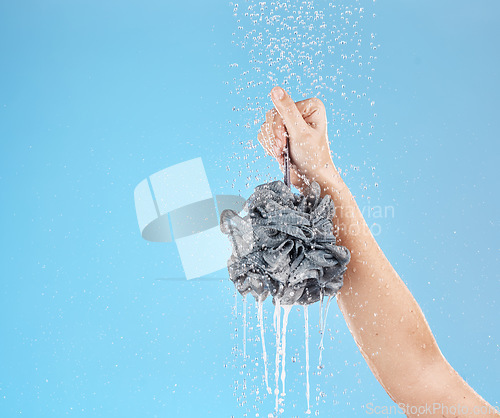 Image of Shower, loofah and hand of woman in studio on blue background mock up. Skincare, water splash and female model holding sponge for showering, washing or bathing for hygiene, health or wellness mockup