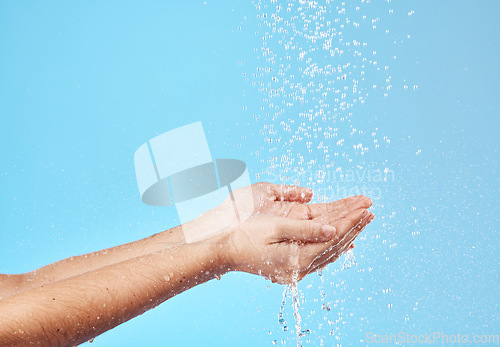 Image of Shower, water and hands of a woman cleaning, saving and catching liquid against blue studio background. Sustainability, wellness and person with care for body, grooming and hygiene with mockup space