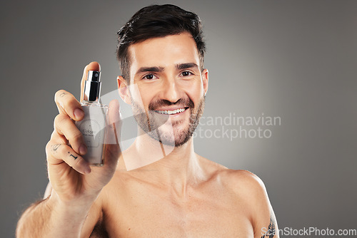 Image of Man, face or body care cologne bottle on gray studio background for morning grooming routine, aroma fragrance or scent spray. Portrait, smile or happy male perfume model and parfume product container