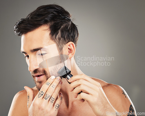 Image of Shave, razor and man cut beard hair for grooming and hygiene or health and wellness on a grey studio background. Epilation, shaving and beauty with electric razor and facial routine for male