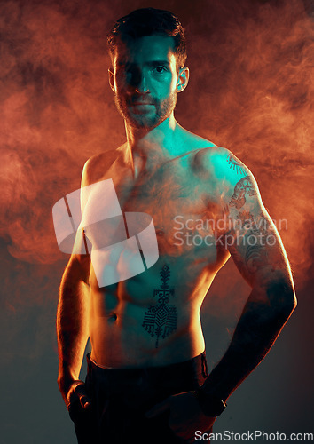 Image of Fashion, body and smoke with a man model in studio on a gray background with red mist for contemporary style. Fitness, beauty and portrait with a topless young handsome male posing in a smokey haze