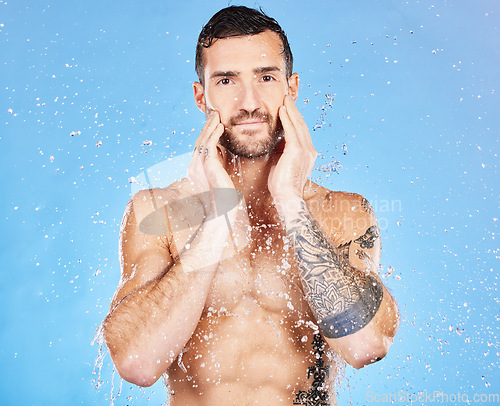 Image of Water, cleaning and man washing face for skincare, wellness and health of body against a blue studio background. Shower, happy and portrait of a model with care for grooming, hygiene and skin