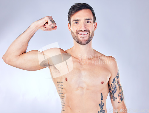 Image of Man, fitness and bicep muscle flex on gray studio background for training, exercise and workout success. Portrait, happy smile or muscular model and athlete showing bodybuilding arm growth or success