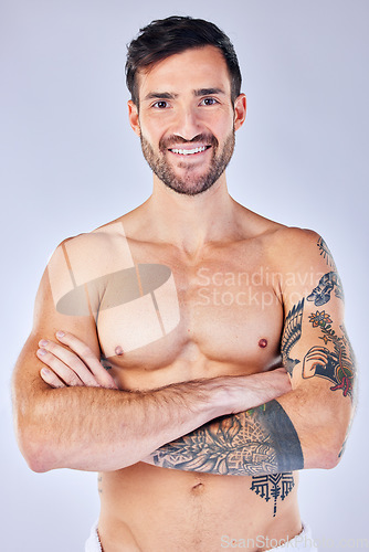 Image of Portrait, body and hygiene with a man model standing arms crossed in studio on a gray background. Health, wellness and skincare with a handsome young male posing arms folded for wellness or luxury