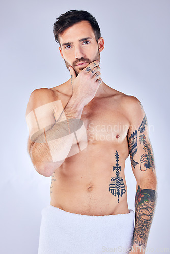 Image of Man, thinking and tattoo with a towel, shower and sexy against grey studio background with mockup space. Portrait, idea and male model with creative body ink, art and after a bath, clean or beauty