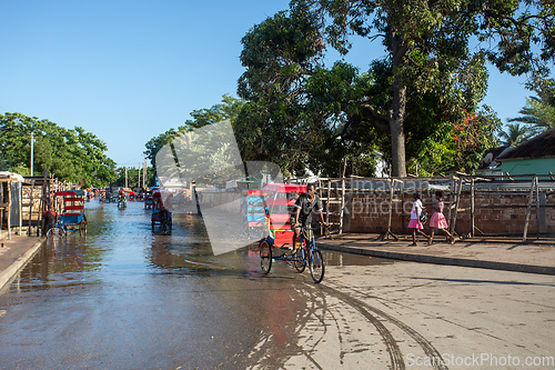 Image of Traditional rickshaw bicycle with Malagasy people on the street of Toliara, one of the ways to earn money. Everyday life on the street of Madagascar.