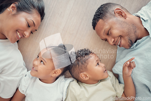 Image of Top view, family and children with smile, on floor and happy together being loving, bonding and childhood in home. Love, parents or toddler twins with happiness, positive and wellness with tenderness