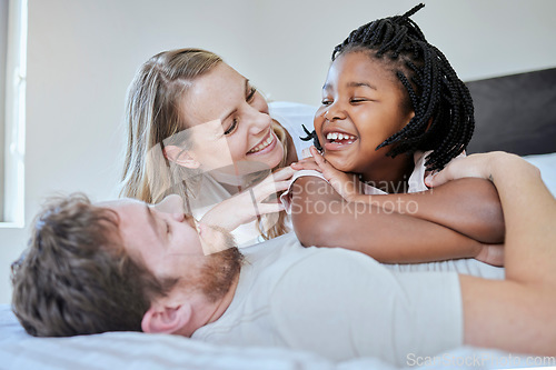 Image of Relax, adoption and diversity with family in bedroom for happy, support and bonding in the morning. Wake up, smile and playing with foster care child and parents at home for affection, trust or funny