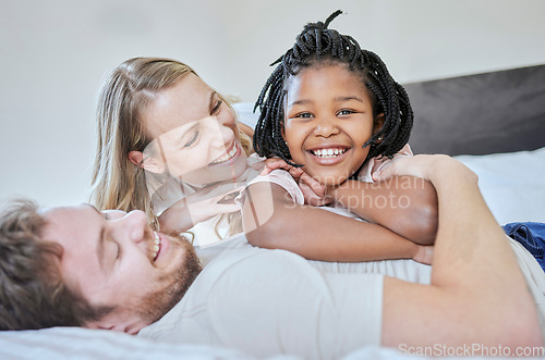 Image of Love, adoption and family portrait, relax and smile on bed in home, happy and support with care. Mother, father and black girl, happiness and freedom in bedroom relaxing, smiling and family home