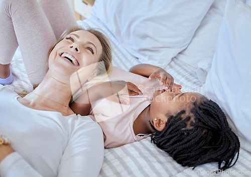 Image of Mother, girl and adoption child in bedroom, family home and house for fun, bonding or quality time with love, care and happiness together. Black kid relax with foster care mom, diversity and laughing