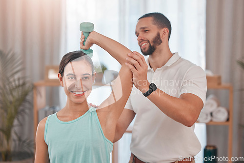 Image of Physical therapy, smile and exercise for shoulder pain of a happy woman with a chiropractor employee. Arm workout weight lifting of a patient feeling relax after a chiropractic and dumbbell lifting