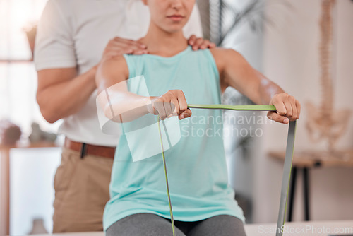 Image of Hands, physiotherapy and rehabilitation with a woman stretching a resistance band in a session at a clinic. Fitness, consultant and rehab with a female patient and physio in an office for recovery