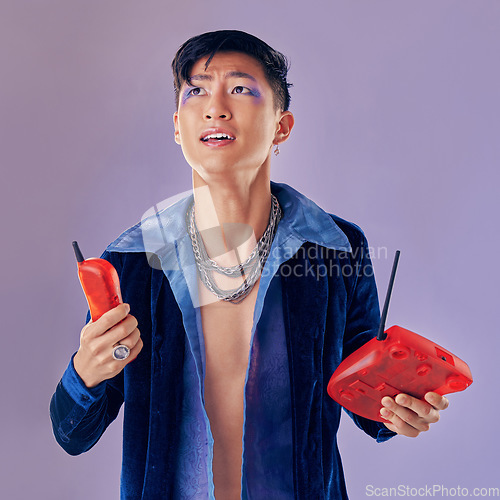 Image of Fashion, telephone and confused man in studio isolated on a purple background. Gen z punk, phone call decline and gay model from Japan in makeup with retro, vintage phone and outdated technology.