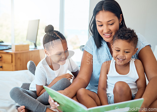 Image of Mother reading a book to her children in a bedroom to relax, bond and learn in their family home. Happiness, education and woman doing storytelling with her kids while relaxing on a bed in a house.