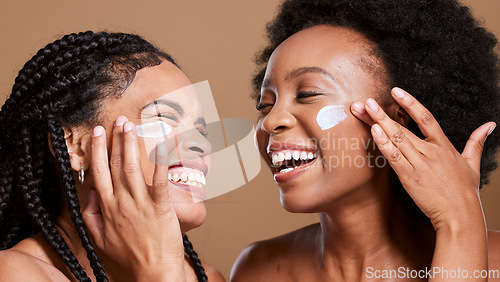 Image of Black woman, cream and skincare with friends support, love and beauty together in studio for cosmetics, makeup cleaning and facial. Excited, diversity model with sunscreen or essential oil on face