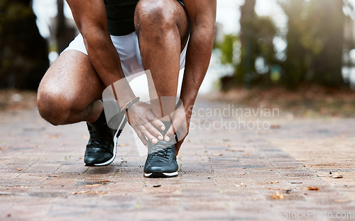 Image of Sports injury, ankle pain and fitness accident of a man doing massage on feet for physical therapy after exercise, workout and training. Athlete runner outdoor for orthopedic health problem on ground