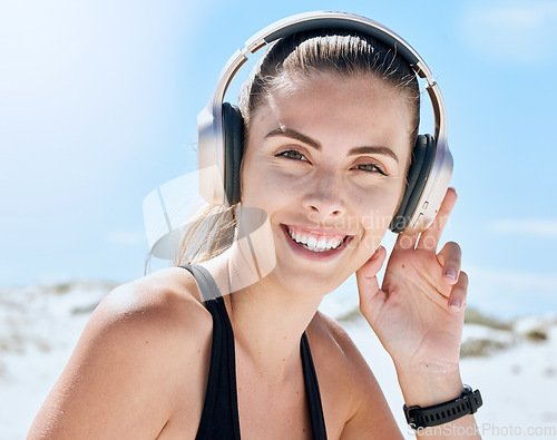 Image of Music, fitness and woman at the beach for exercise, wellness and cardio training while listening to radio. Podcast, workout and portrait of girl relax, smile and enjoy motivation audio track for run