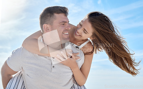 Image of Love, blue sky and bonding couple hug while on honeymoon vacation date for romance, quality time or outdoor freedom. Peace, trust partnership and fun marriage people play piggyback in Toronto Canada