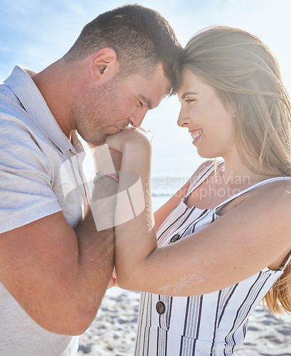 Image of Love, affection and couple with kiss at the beach on a romantic date to relax together in summer. Trust, care and man with gratitude, care and respect for a woman by the ocean on a travel holiday