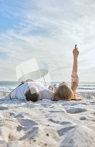 Image of Beach, relax and couple watching the sky while on a seaside vacation, adventure or journey. Travel, calm and man and woman resting together in nature by the ocean while on holiday in Australia.