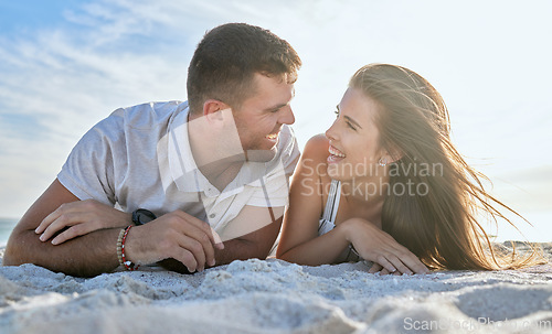 Image of Love, ocean and couple laying on beach, man and woman relax on summer morning date. Travel, sea and happy couple on sand, spending time together in nature and romance on luxury vacation in Australia.