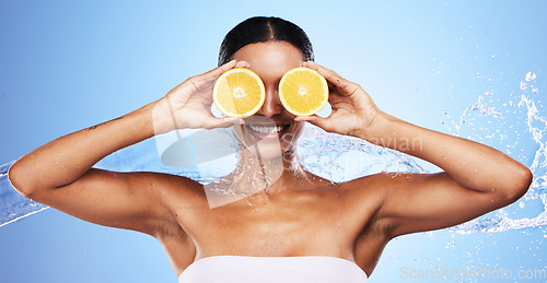 Image of Orange, skincare and woman with water splash smile about fruit, wellness and vitamin c health. Skin beauty, facial and cosmetic eye treatment of a black woman model with happiness about nutrition