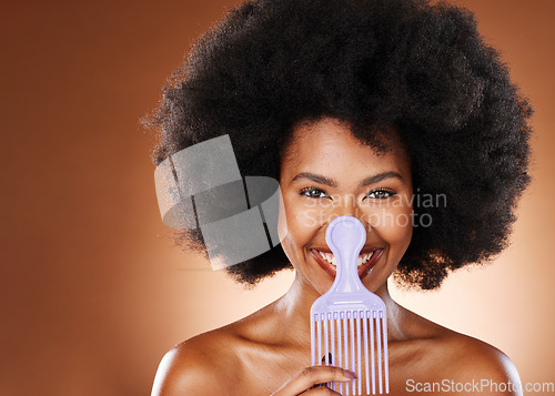 Image of Comb, black woman and hair care with smile, happy and cosmetics for wellness, relax and with brown studio background. Portrait, African American female and girl with afro, massage scalp and grooming.