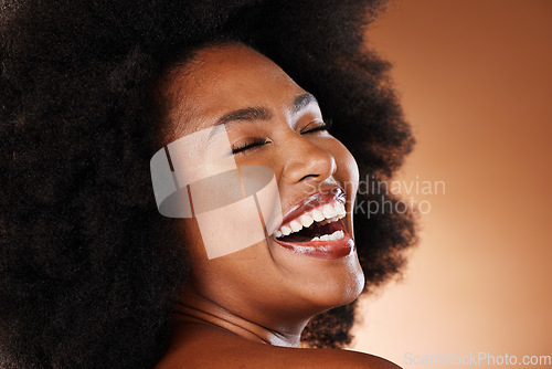 Image of Black woman, afro hair and laughing face expression on studio background in self love, empowerment or acceptance. Zoom, smile or happy beauty model with natural hair, white teeth and makeup cosmetics
