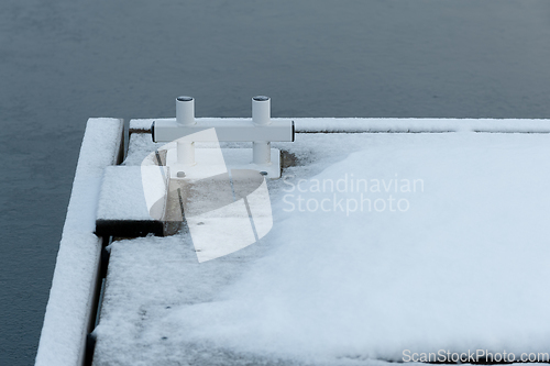 Image of snow-covered quayside with construction for mooring boats