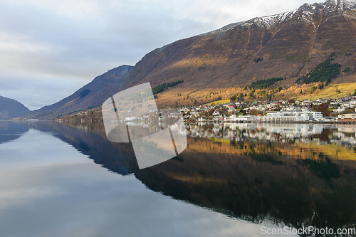 Image of small town mirrors in the sea with a streak of sun