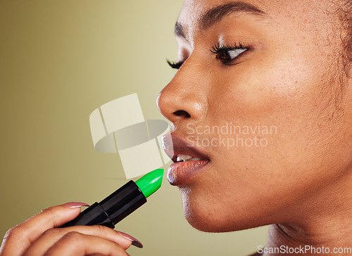 Image of Woman, mouth and lipstick for makeup and cosmetic beauty aesthetic on a green studio background. Black woman, green lipstick glamour for lipbalm, skincare and pout treatment for plump lips