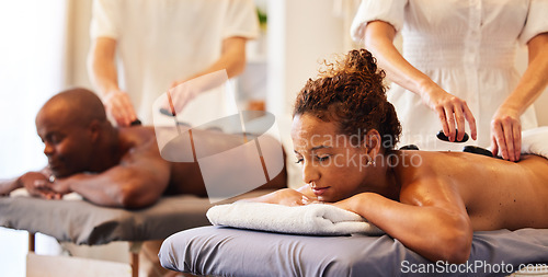 Image of Couple massage, rock or spa therapist for relax, luxury or wellness treatment for health, self care or zen at resort. Healthcare, beauty salon or black woman and man for healthy, skincare or therapy