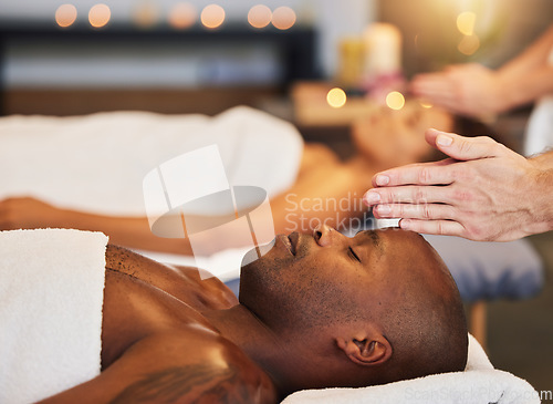 Image of Hands, massage and relax with a black man customer in a spa for physical therapy or rest in a resort. Luxury, wellness and zen with a male client lying on a bed for stress relief at a lodge
