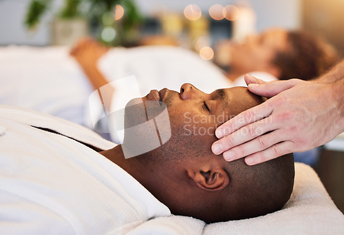 Image of Black man, relax and head massage with therapist hands in a luxury spa, wellness and skincare on a bed. Masseur with relax client in zen, calm or peace luxury hotel salon for physical body therapy