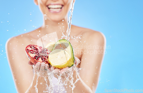 Image of Cleaning, water and hands with fruit in studio on blue background for nutrition, natural and healthy lifestyle. Wellness, body care and woman with fruits and vegetables with water splash for diet