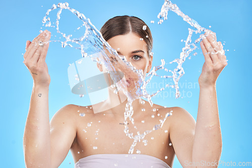 Image of Water splash, woman and skincare beauty for skin health, wellness and organic cosmetics healthcare routine mockup. Clean face, model facial cleaning and liquid spa treatment on blue studio background