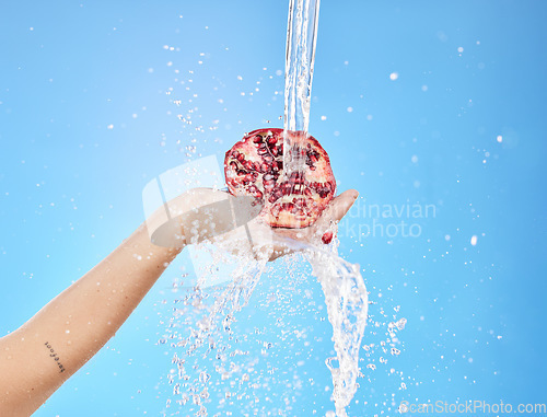 Image of Water, splash and pomegranate with hands of woman for health, antioxidant and nutrition. Summer, organic and fruit with girl model for vitamin c for diet, food and clean detox in blue background