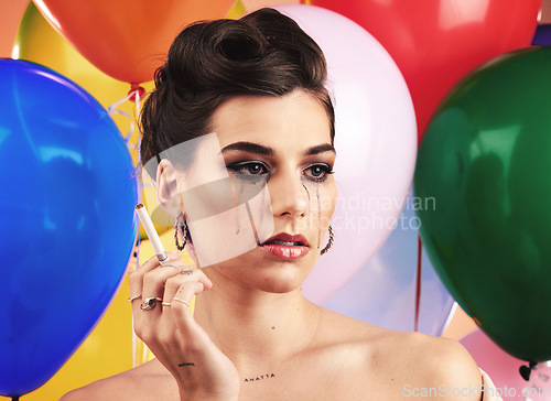 Image of Party balloon and makeup woman crying with sad, depressed and disappointed tears on face. Thinking, depression and mental health problem of girl at event smoking cigarette with sadness.