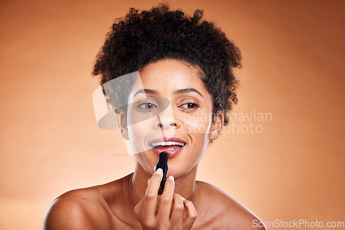 Image of Black woman, afro and face glow lipstick on studio background for morning grooming routine, self care or satisfaction. Smile, happy or beauty model with lip gloss, makeup cosmetics and color product