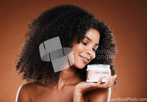 Image of Beauty, haircare and product with a model black woman in studio on a brown background for treatment. Container, hair mask and wellness with an attractive young female posing to promote cosmetics