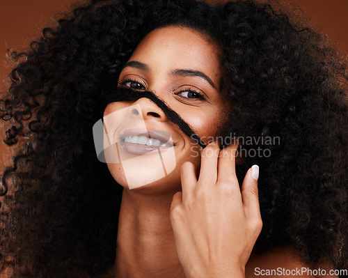 Image of Black woman afro, hand and smile for hair cosmetics, care or treatment against a studio background. Portrait of African American female model smiling with teeth in satisfaction for salon hairstyle