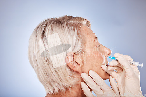 Image of Plastic surgery, senior woman and injection for botox, toned skin and health with grey studio background. Mature female, elderly lady and needle for wellness, to relax facial muscles and anti aging.