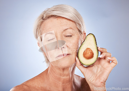 Image of Mature, beauty and skincare with a woman and an avocado for smooth, soft skin on a grey background. Anti aging, skin care facial treatment with fresh food for senior female with avo for health