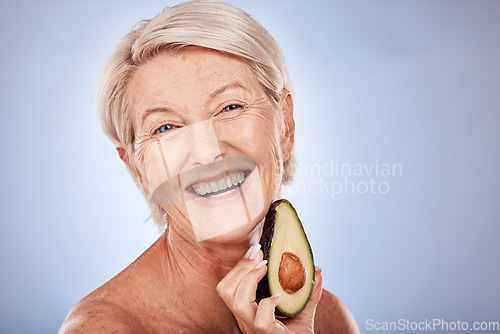 Image of Senior woman with avocado, natural skincare for plant based product with healthy ingredient. Portrait of happy elderly lady, smile with fruit for face mask and vegan cruelty free lifestyle in studio