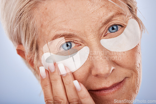 Image of Face, beauty and eye mask with a senior woman in studio on a gray background for antiaging treatment. Portrait, cosmetics and wrinkles with a mature female posing to promote a natural product