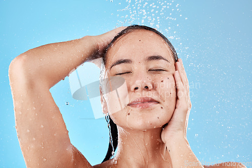 Image of Beauty, skincare and hair, woman in shower on blue background, haircare and hygiene routine in the morning. Model in water splash, cleaning hair and face with running water for clean fresh lifestyle.